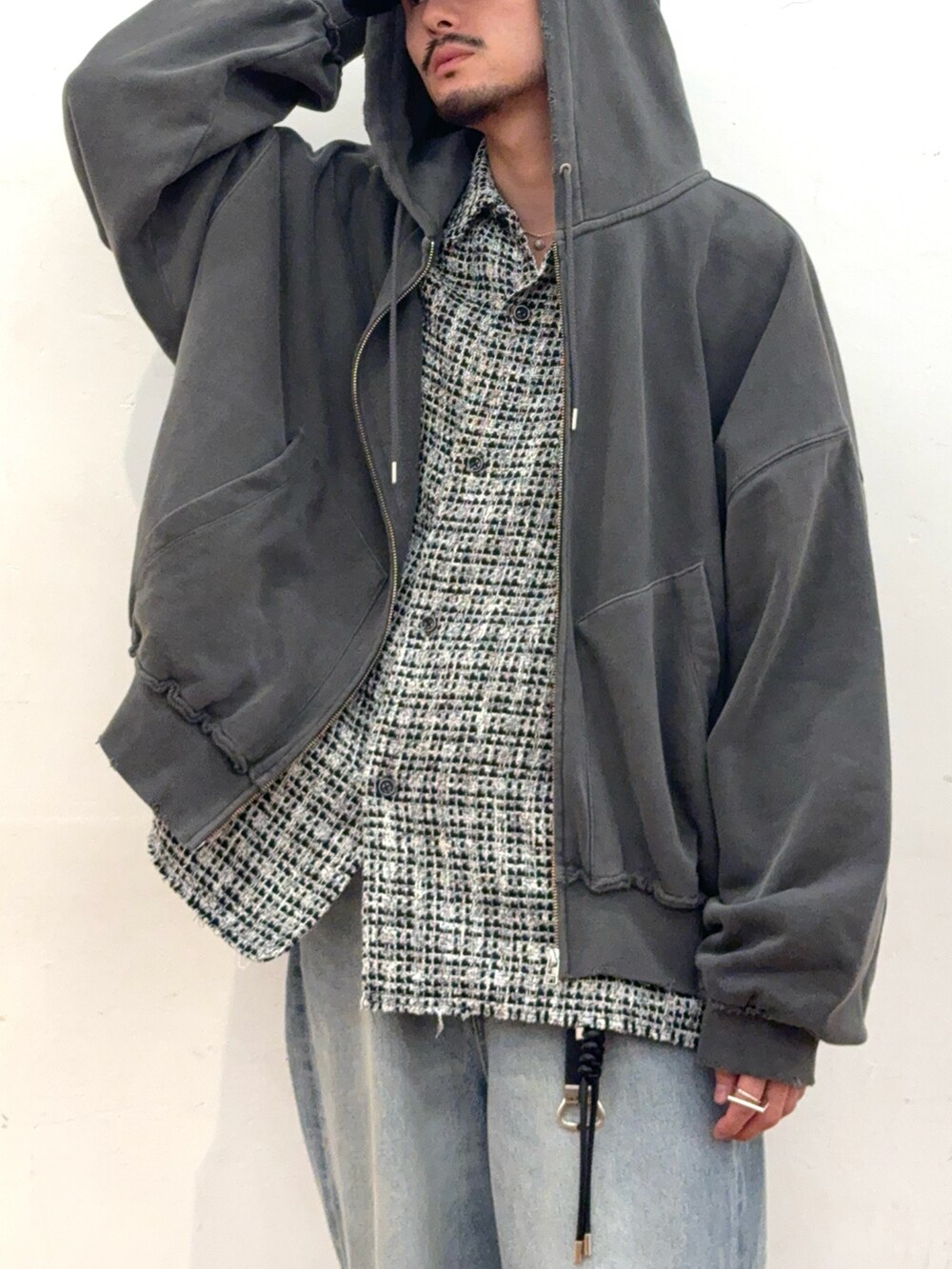 グレー系のパーカー、ブラック系のシャツ/ブラウス、ブルー系のデニムパンツを着用したメンズの秋コーディネートの2枚目の写真