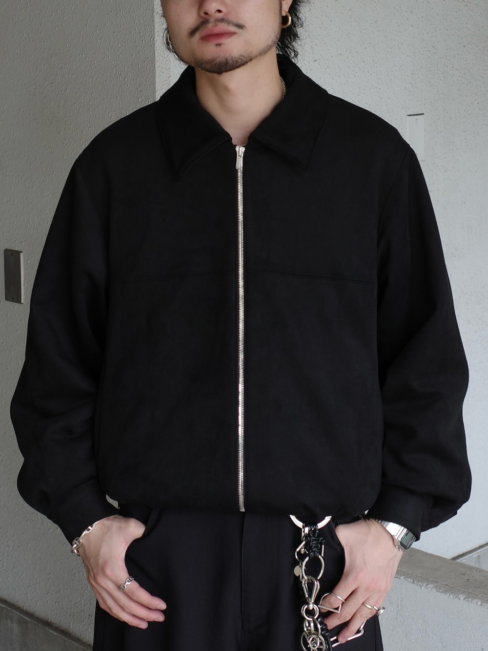 ブラック系のブルゾン、ブルー系のニット/セーター、ブラック系のスラックスを着用したメンズの冬コーディネートの5枚目の写真