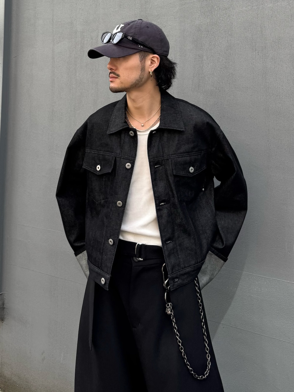 ブラック系のデニムジャケット、ブラック系のスラックス、ブラック系のウォレットチェーンを着用したメンズの春コーディネートの7枚目の写真