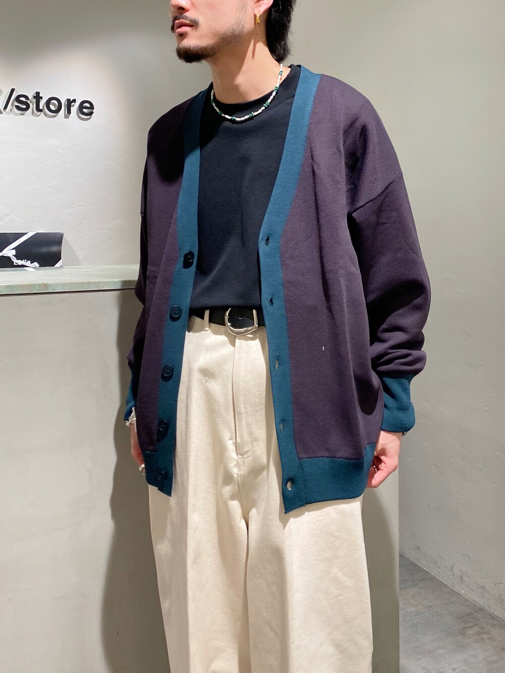 グレー系のカーディガン/ボレロ、ホワイト系のデニムパンツ、ホワイト系のブーツを着用したメンズの春コーディネートの3枚目の写真