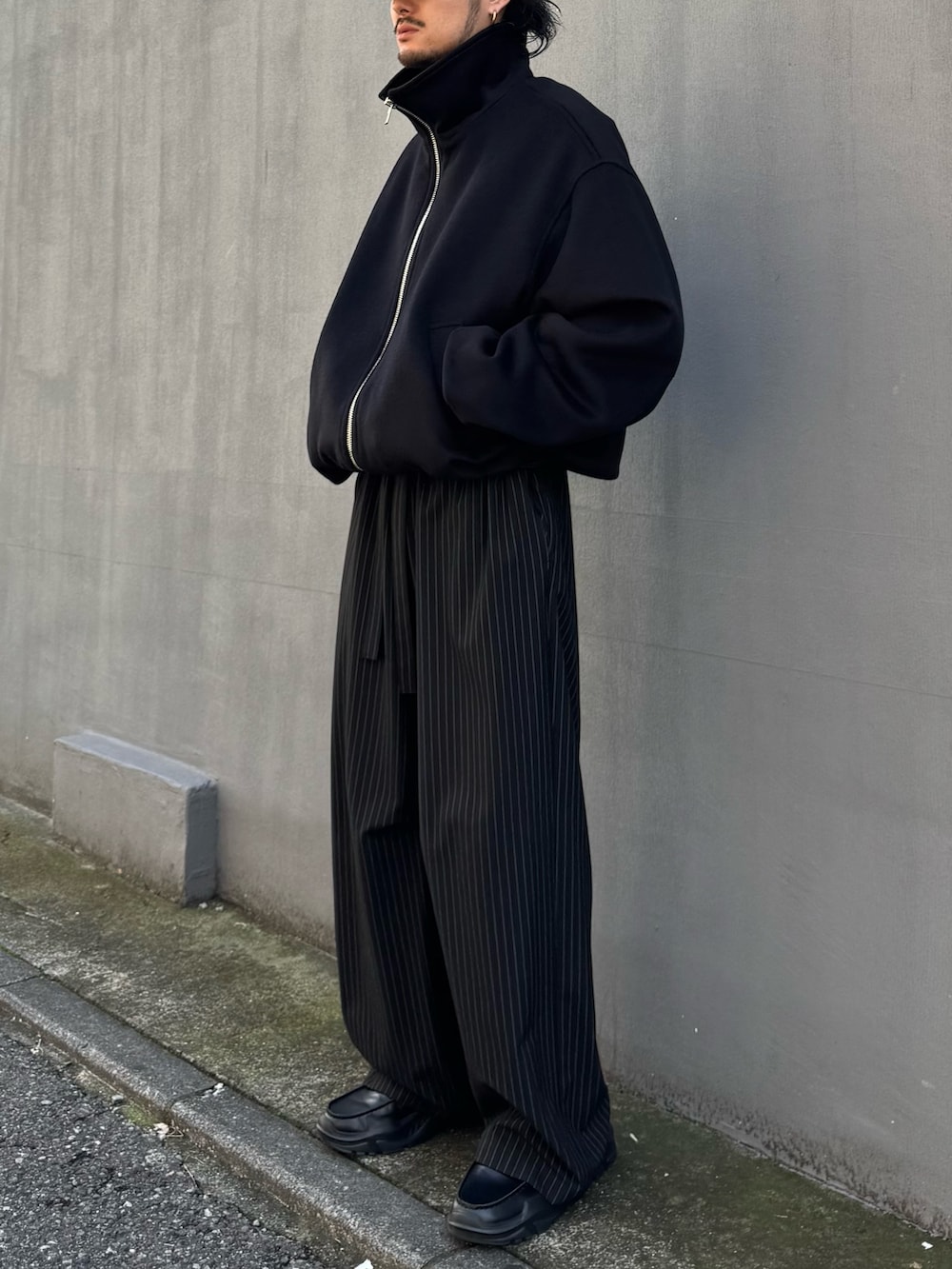 ブラウン系のニット/セーター、ブラック系のその他パンツ、ブラック系のローファーを着用したメンズの秋コーディネートの4枚目の写真