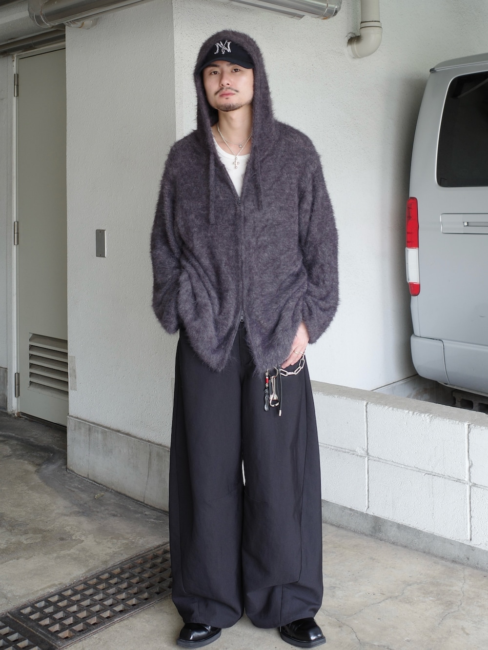 ブラック系のスラックス、グレー系のニット/セーターを着用したメンズの冬コーディネートの2枚目の写真