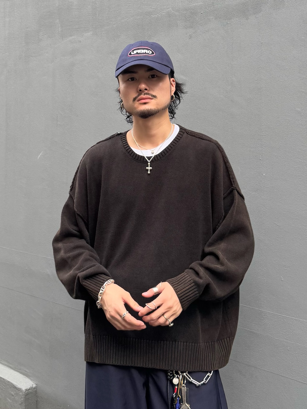 ブラック系のニット/セーター、ブルー系のスラックス、ブルー系のキャップを着用したメンズの秋コーディネートの5枚目の写真