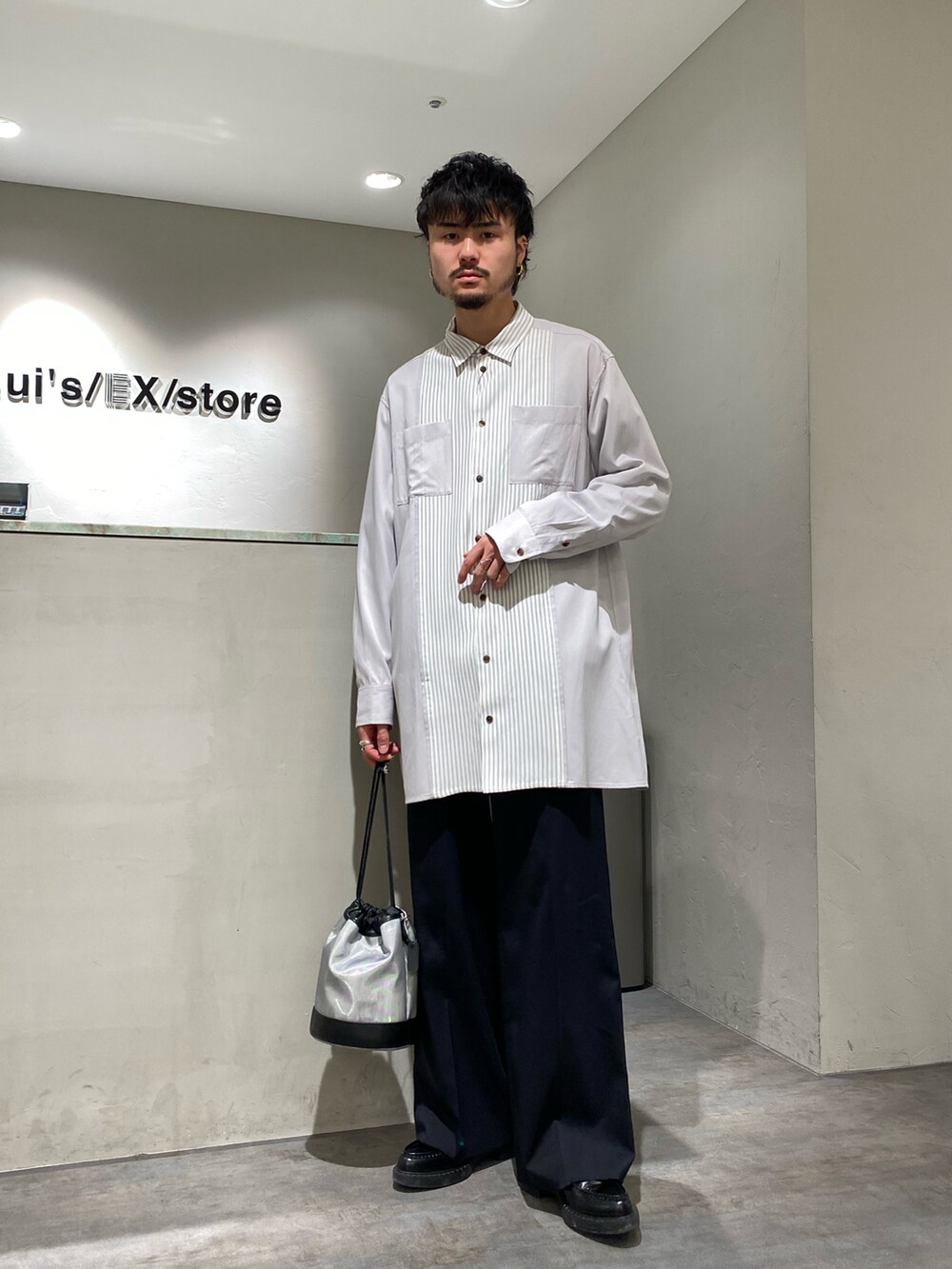 グレー系のシャツ/ブラウス、ブラック系のスラックス、シルバー系のショルダーバッグを着用したメンズの春コーディネートの2枚目の写真