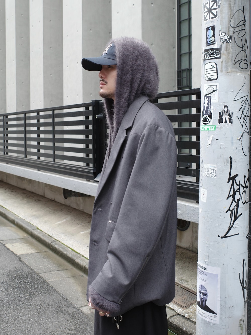 グレー系のテーラードジャケット、ブラック系のスラックス、グレー系のニット/セーターを着用したメンズの秋コーディネートの5枚目の写真