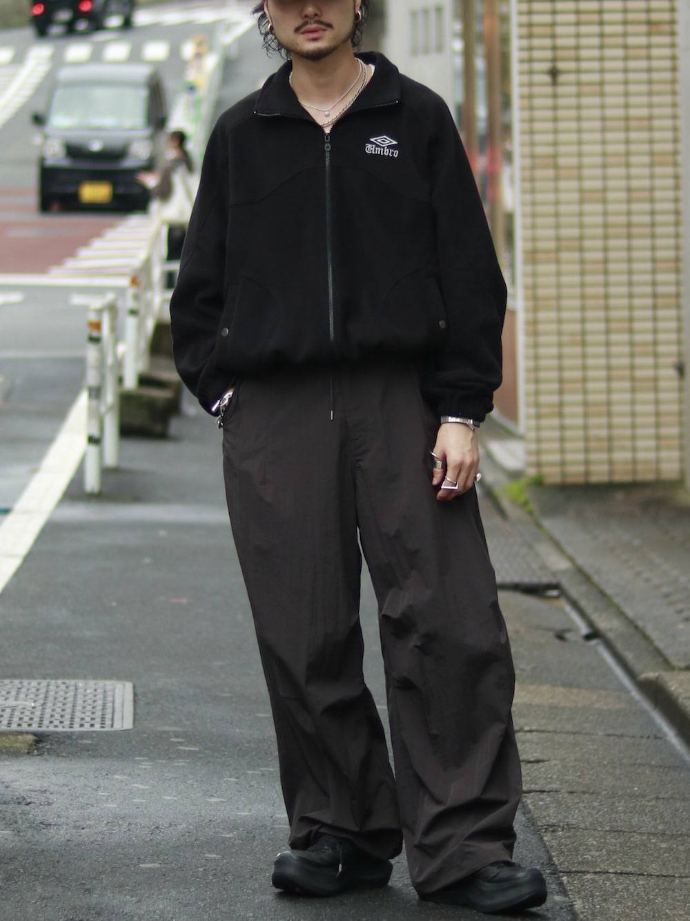 ブラック系のブルゾン、グレー系のその他パンツを着用したメンズの秋コーディネートの2枚目の写真