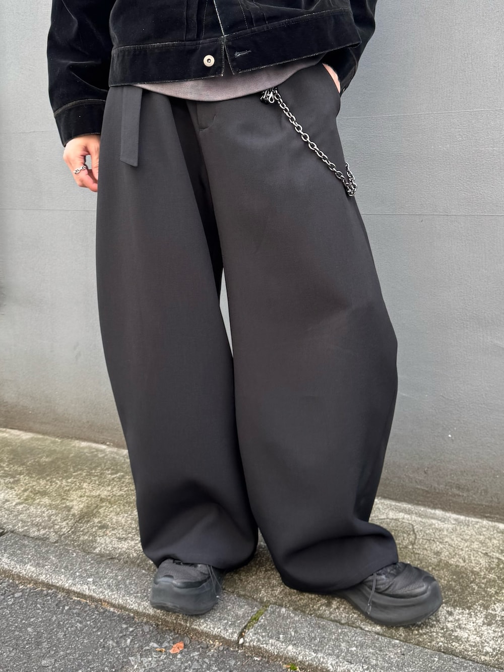 ブラック系のデニムジャケット、ブラック系のスラックス、ブラック系のウォレットチェーンを着用したメンズの春コーディネートの7枚目の写真