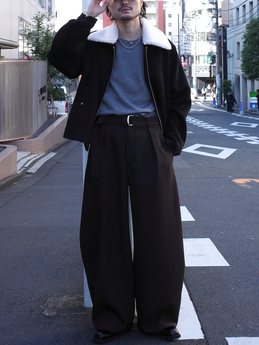 グレー系のニット/セーター、ブラック系のブルゾン、グレー系のスラックスを着用したメンズの秋コーディネートの4枚目の写真