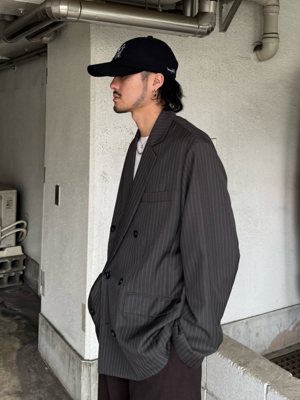 グレー系のテーラードジャケット、グレー系のスラックス、ホワイト系のTシャツ/カットソーを着用したメンズの春コーディネートの6枚目の写真