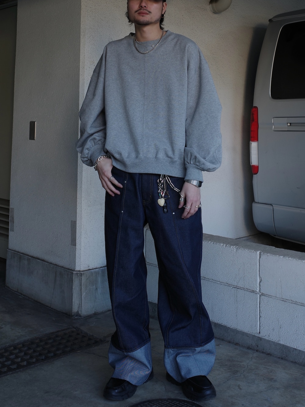 グレー系のスウェット、ブルー系のデニムパンツを着用したメンズの春コーディネートの3枚目の写真