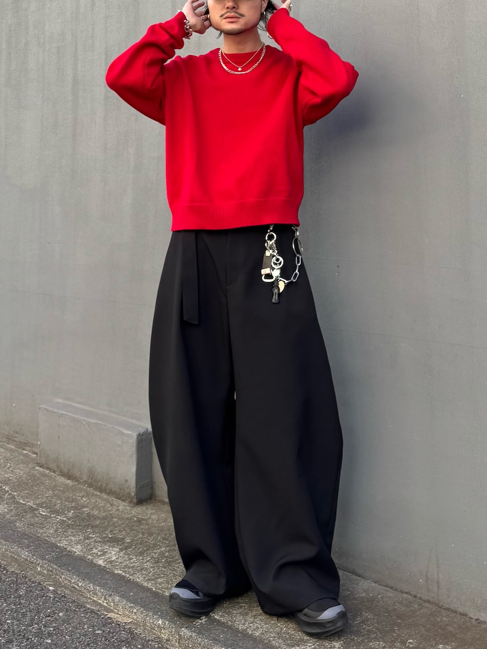 レッド系のニット/セーター、ブラック系のスラックスを着用したメンズの冬コーディネートの4枚目の写真