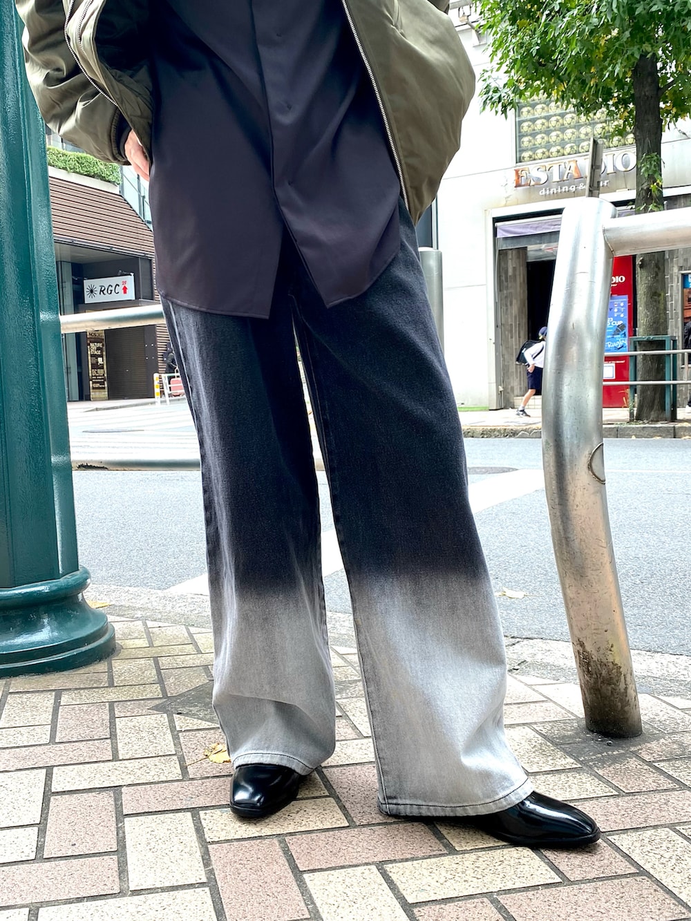 グリーン系のMA-1、ブラック系のデニムパンツ、ブラック系のブーツを着用したメンズの秋コーディネートの4枚目の写真