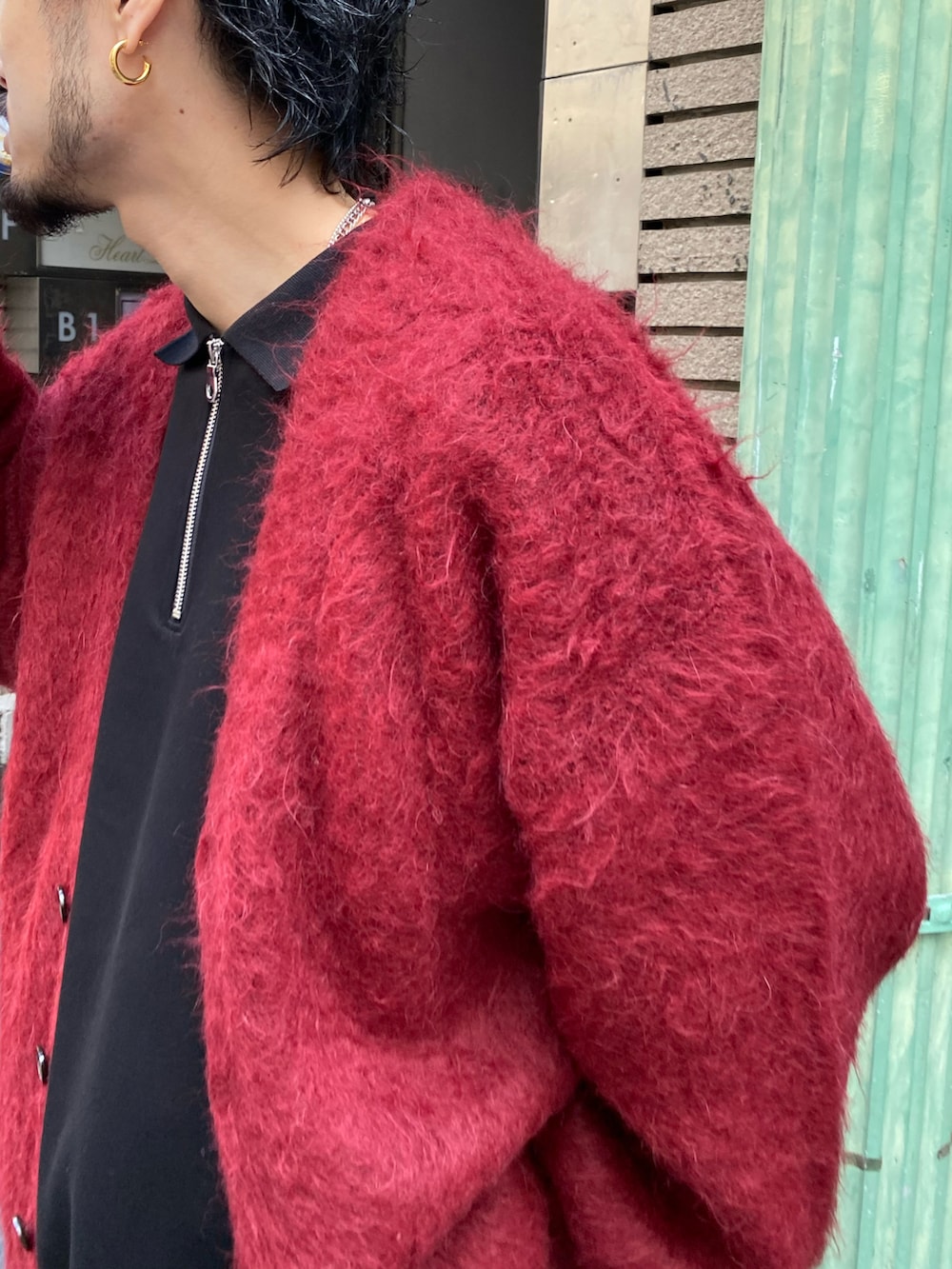 レッド系のカーディガン/ボレロ、ブラック系のデニムパンツ、ブラック系のTシャツ/カットソーを着用したメンズの秋コーディネートの3枚目の写真