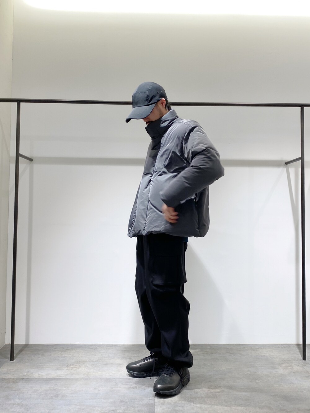 グレー系のダウンジャケット/コート、ブラック系のカーゴパンツ、ブラック系のスニーカーを着用したメンズの冬コーディネートの2枚目の写真