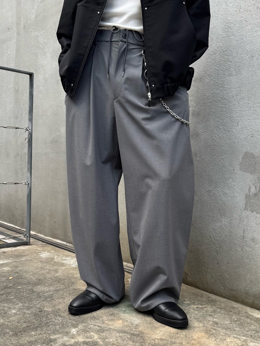 ブラック系のブルゾン、グレー系のスラックスを着用したメンズの秋コーディネートの5枚目の写真