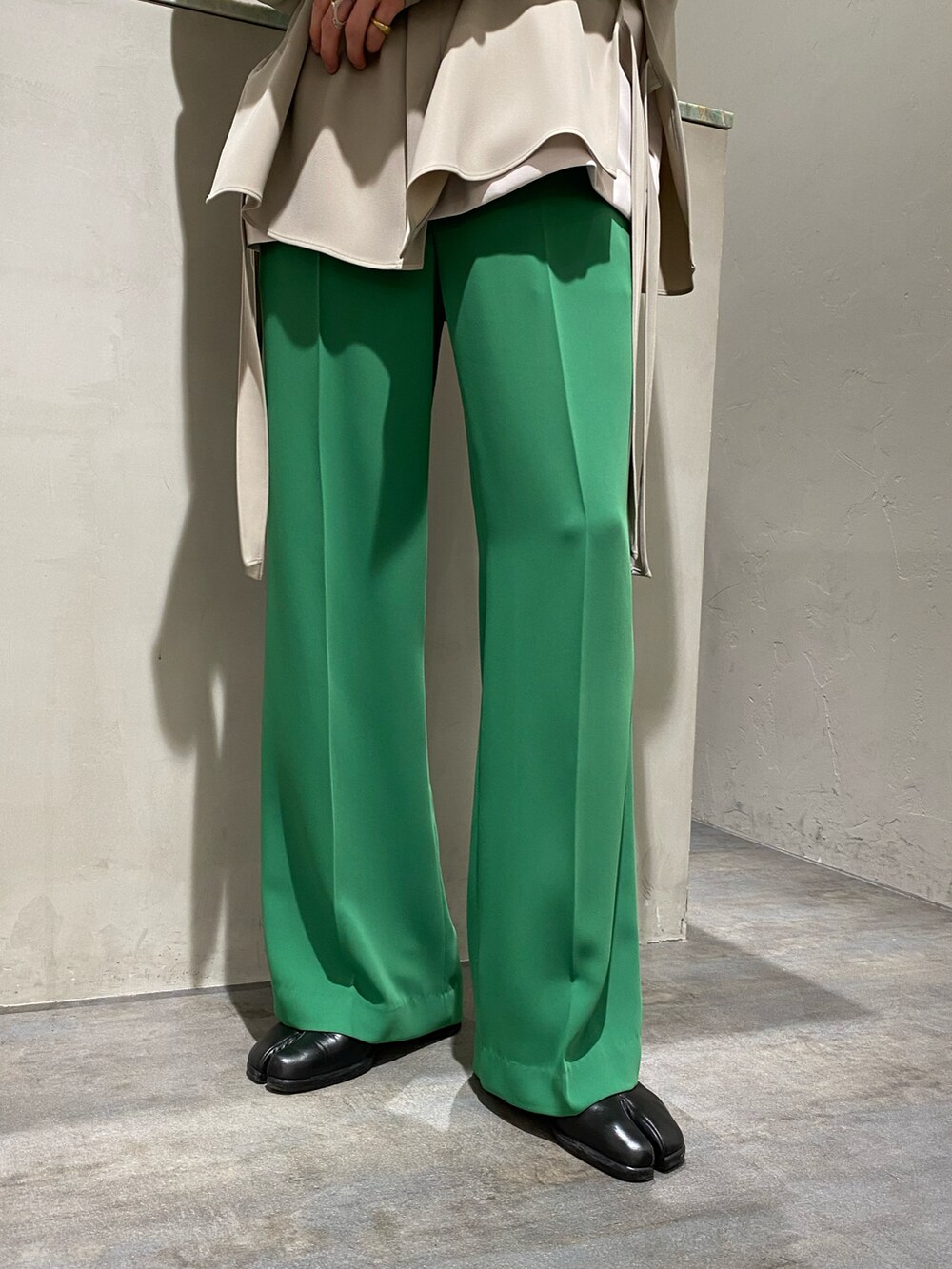 ホワイト系のテーラードジャケット、ベージュ系のトップス、グリーン系のスラックスを着用したメンズの春コーディネートの3枚目の写真