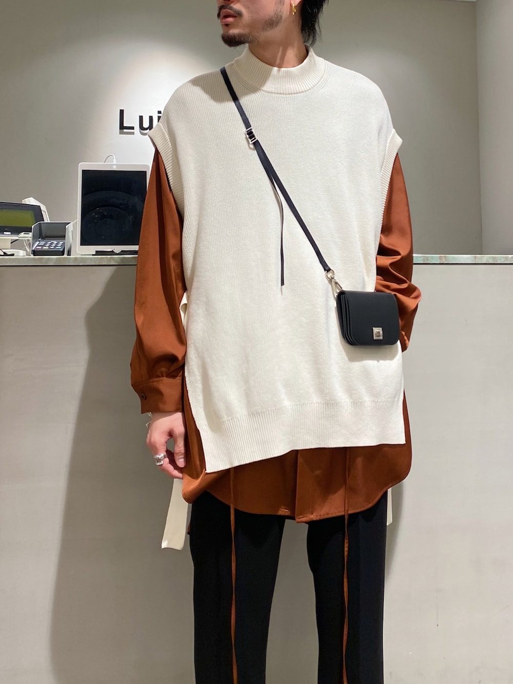 ホワイト系のベスト、ブラウン系のシャツ/ブラウス、ブラック系のスラックスを着用したメンズの春コーディネートの3枚目の写真