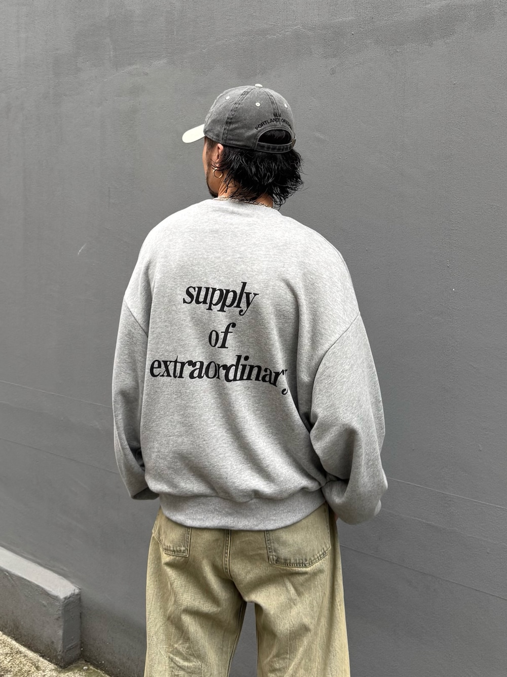 グレー系のTシャツ/カットソー、グリーン系のデニムパンツを着用したメンズの夏コーディネートの5枚目の写真