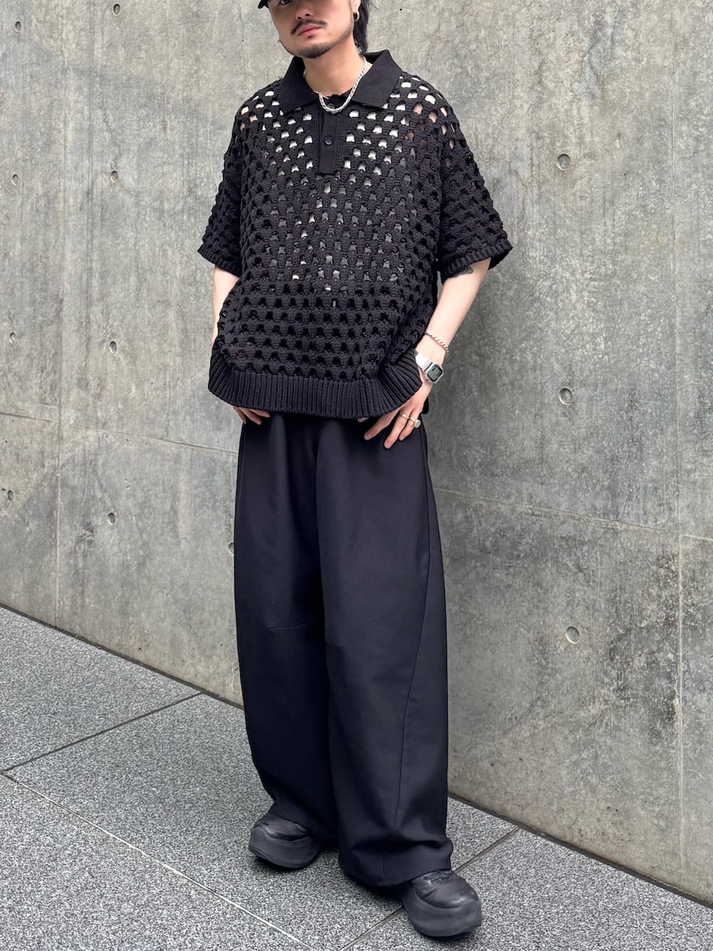 ブラック系のニット/セーター、ブラック系のスラックスを着用したメンズの春コーディネートの2枚目の写真