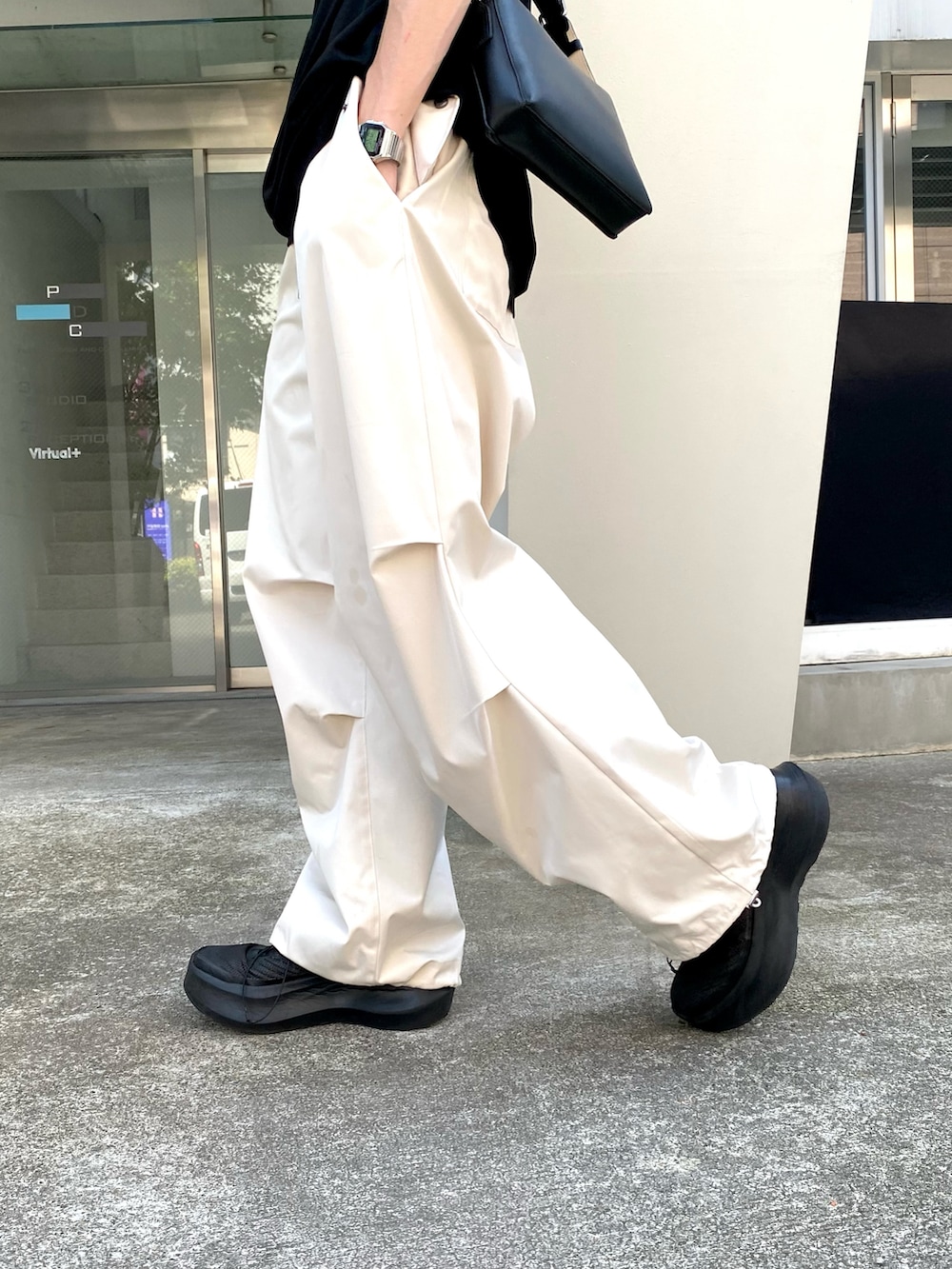 ブラック系のTシャツ/カットソー、ホワイト系のその他パンツ、ブラック系のショルダーバッグを着用したメンズの夏コーディネートの3枚目の写真