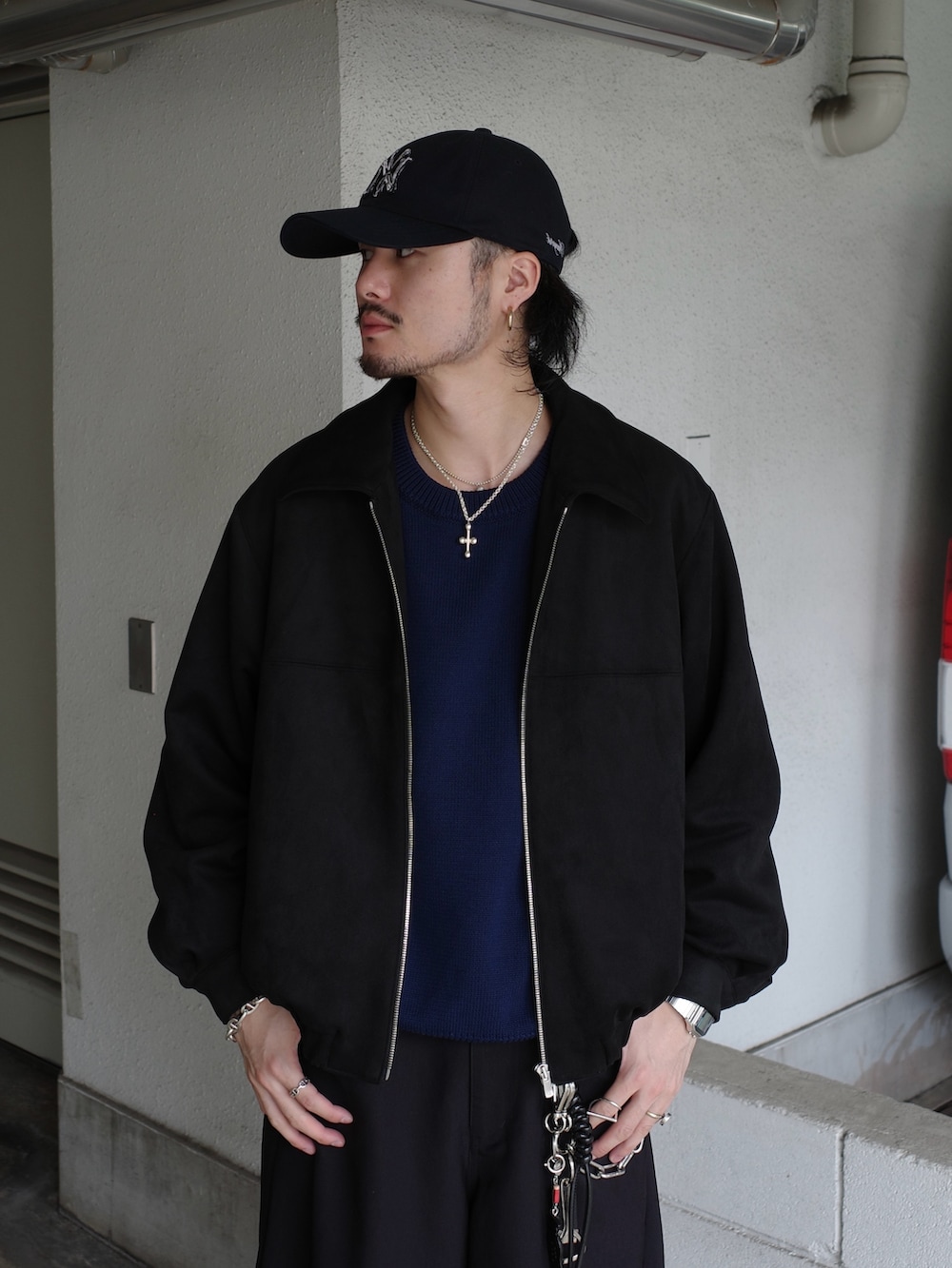 ブラック系のブルゾン、ブルー系のニット/セーター、ブラック系のスラックスを着用したメンズの冬コーディネートの3枚目の写真