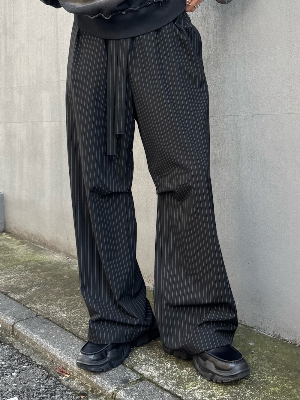 ブラック系のスウェット、ブラック系のその他パンツ、ブラック系のローファーを着用したメンズの秋コーディネートの6枚目の写真