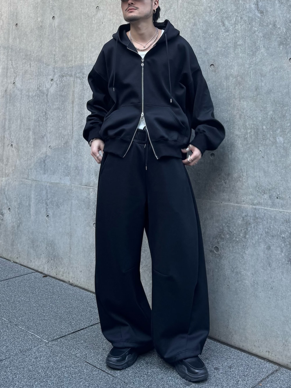 ブラック系のパーカー、ブラック系のローファー、ブラック系のその他パンツを着用したメンズの冬コーディネートの4枚目の写真