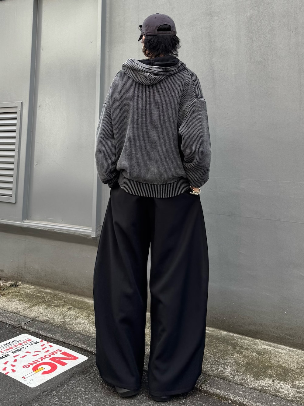 グレー系のパーカー、ブラック系のスラックス、グレー系のスウェットを着用したメンズの春コーディネートの3枚目の写真