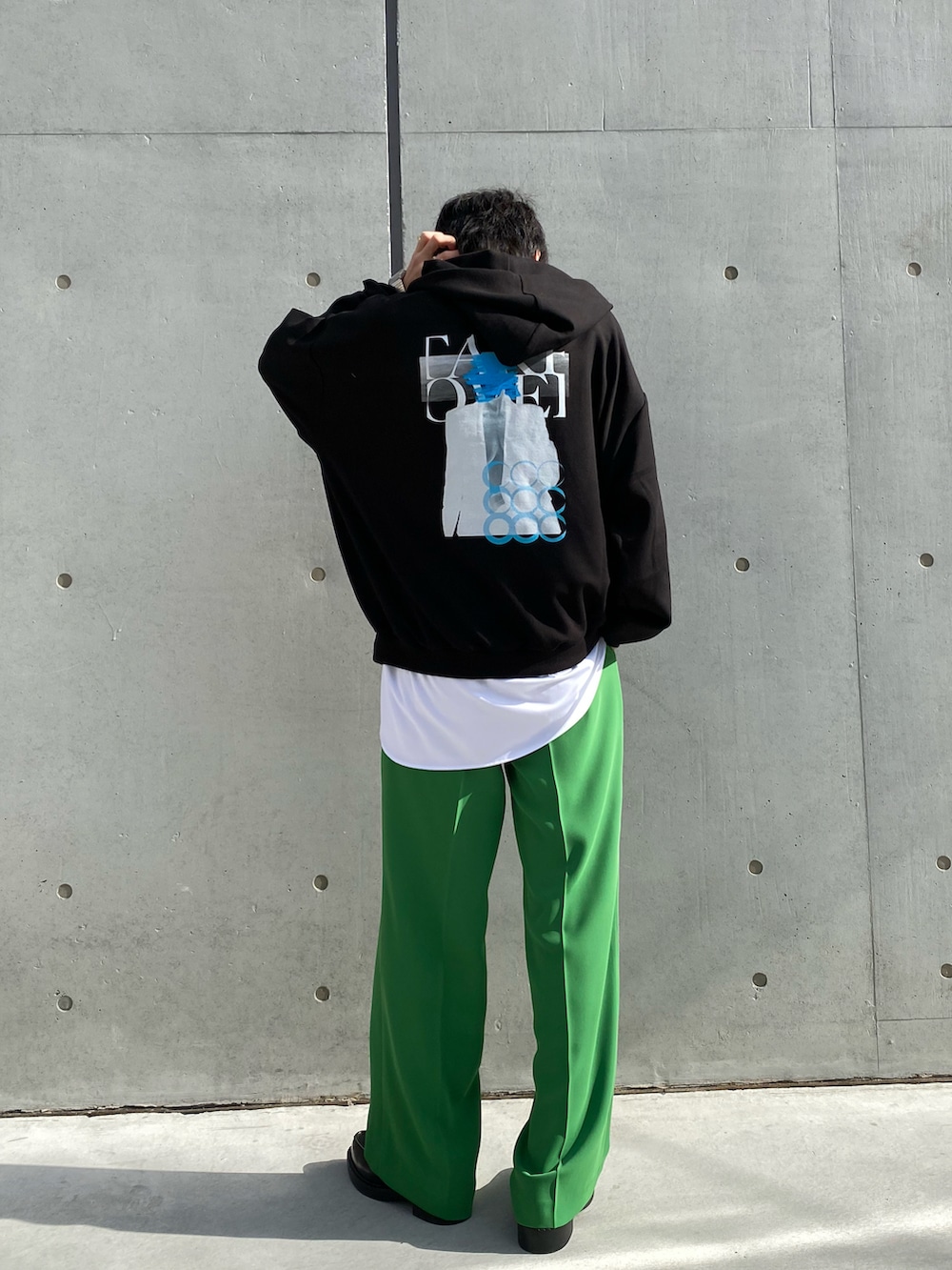 ブラック系のパーカー、ホワイト系のシャツ/ブラウス、グリーン系のスラックスを着用したメンズの冬コーディネートの2枚目の写真