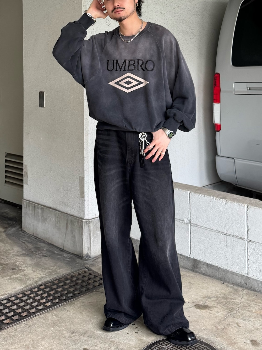 グレー系のスウェット、ブラック系のデニムパンツを着用したメンズの春コーディネートの2枚目の写真