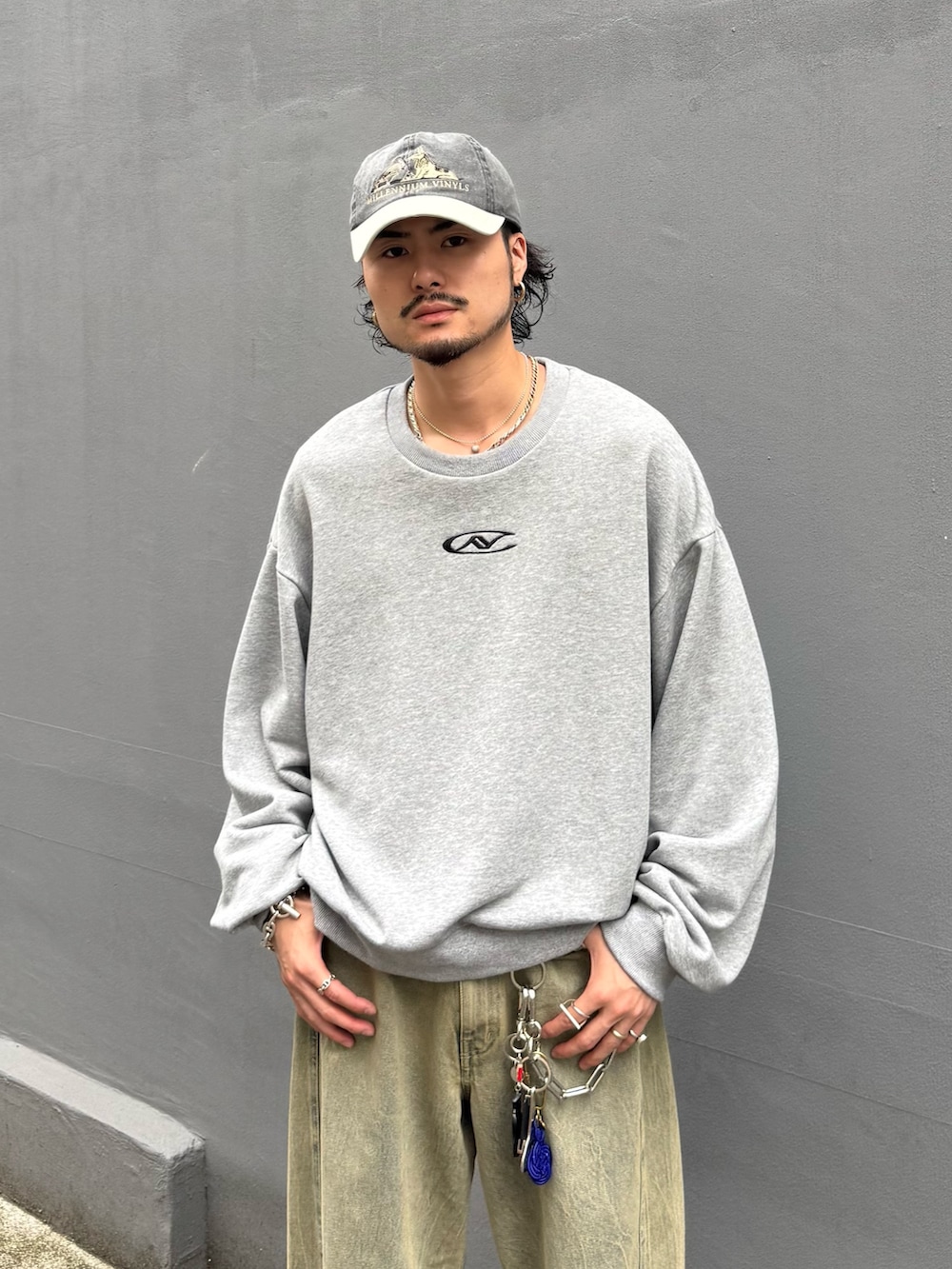 グレー系のTシャツ/カットソー、グリーン系のデニムパンツを着用したメンズの夏コーディネートの4枚目の写真