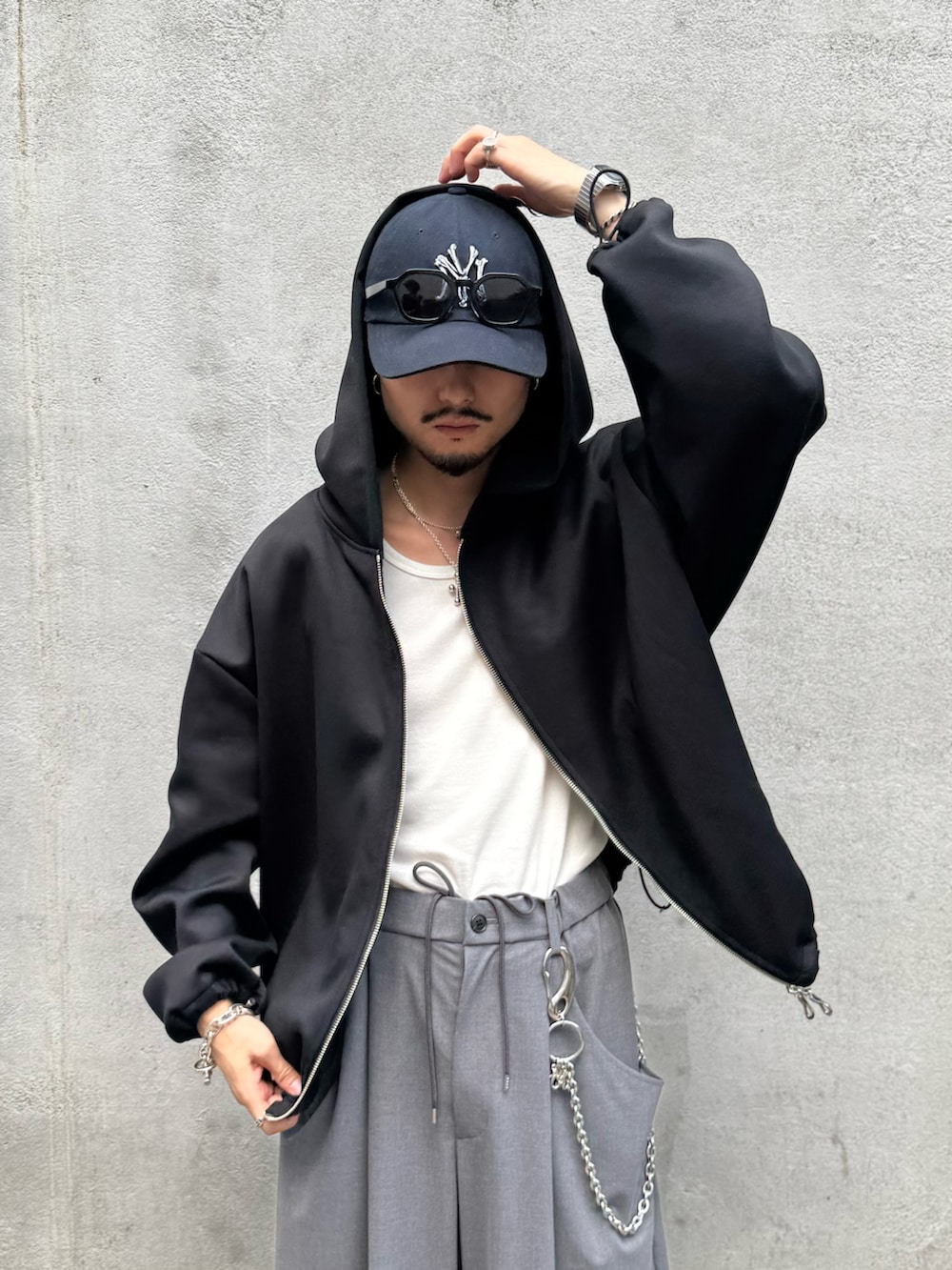 ブラック系のパーカー、グレー系のスラックス、シルバー系のウォレットチェーンを着用したメンズの秋コーディネートの7枚目の写真