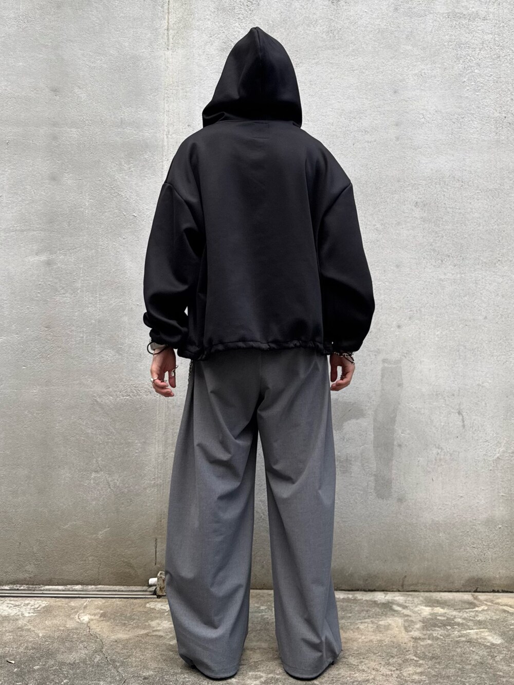 ブラック系のパーカー、グレー系のスラックス、シルバー系のウォレットチェーンを着用したメンズの秋コーディネートの5枚目の写真