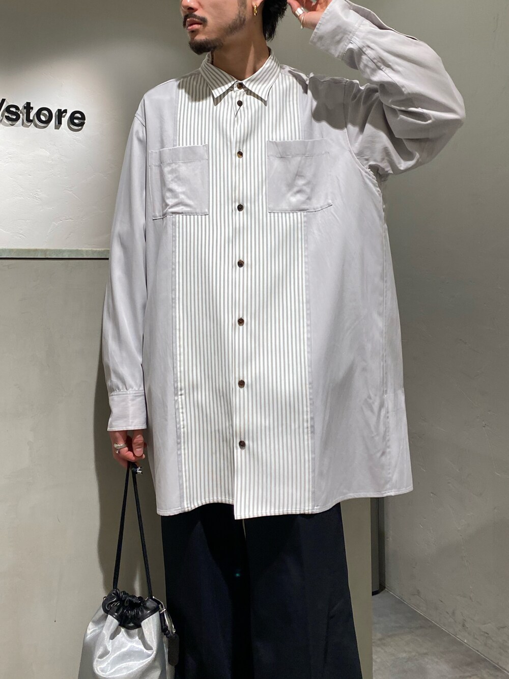 グレー系のシャツ/ブラウス、ブラック系のスラックス、シルバー系のショルダーバッグを着用したメンズの春コーディネートの3枚目の写真