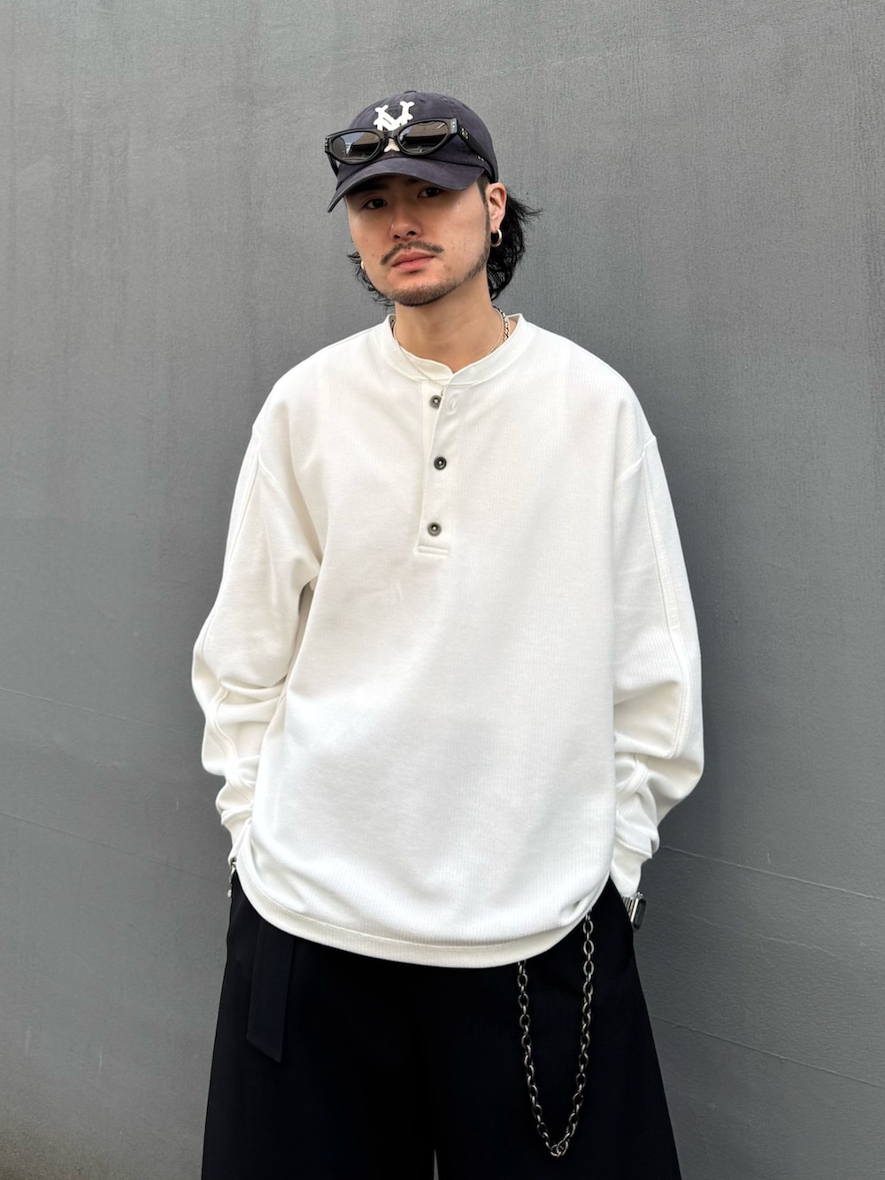 ホワイト系のTシャツ/カットソー、ブラック系のスラックス、ブラック系のウォレットチェーンを着用したメンズの春コーディネートの4枚目の写真