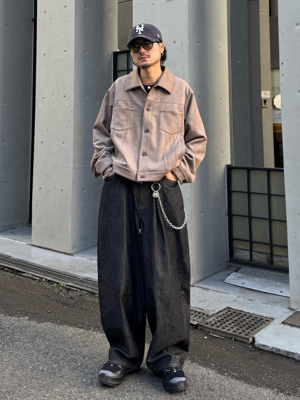 グレー系のブルゾン、ブルー系のニット/セーター、ブラック系のデニムパンツを着用したメンズの冬コーディネートの3枚目の写真