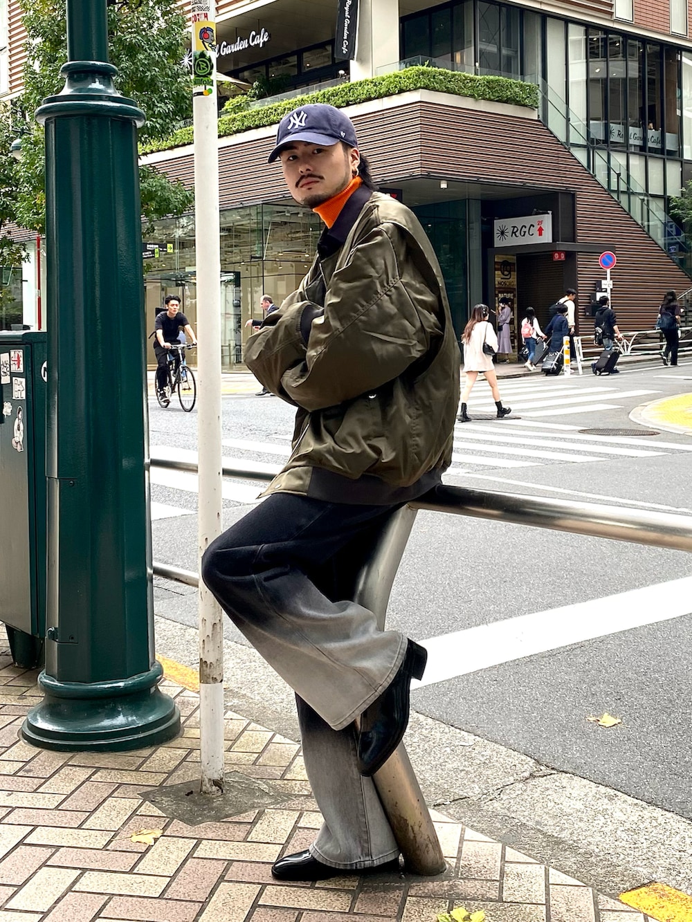 グリーン系のMA-1、ブラック系のデニムパンツ、ブラック系のブーツを着用したメンズの秋コーディネートの2枚目の写真