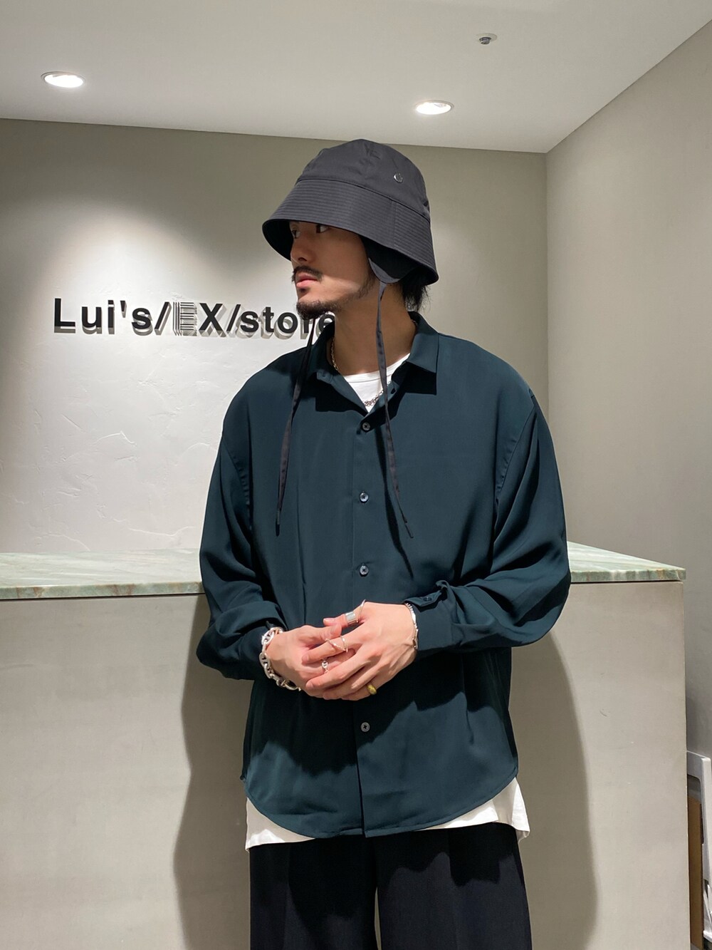 グリーン系のシャツ/ブラウス、ブラック系のスラックス、ブラック系のドレスシューズを着用したメンズの夏コーディネートの3枚目の写真