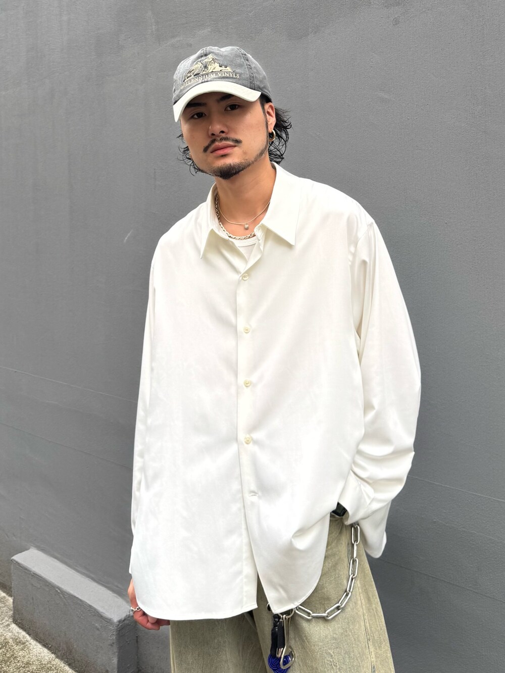 ホワイト系のトップス、グリーン系のデニムパンツを着用したメンズの夏コーディネートの3枚目の写真