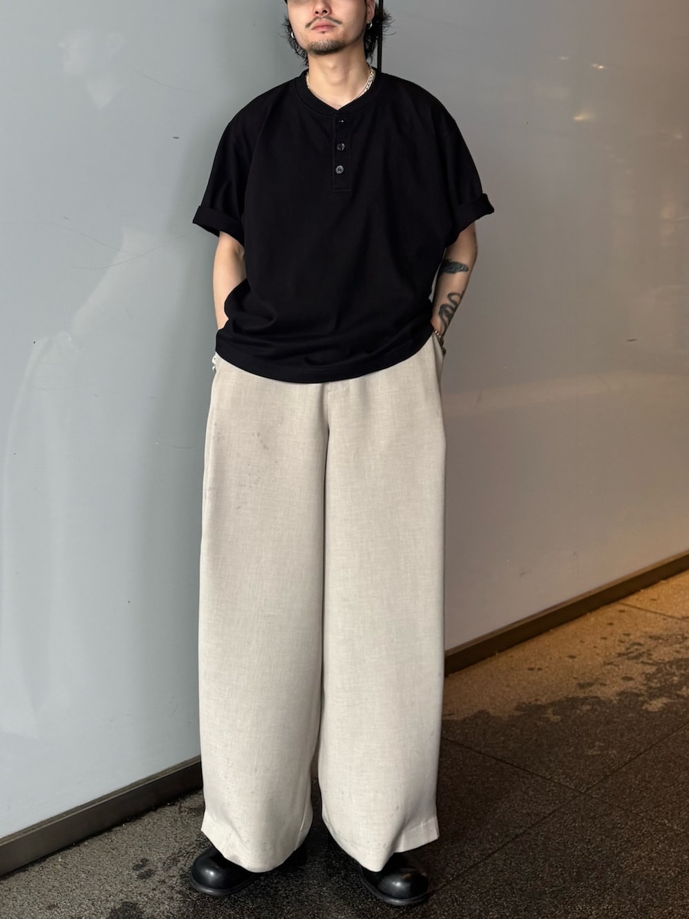ブラック系のTシャツ/カットソー、ベージュ系のスラックスを着用したメンズの春コーディネートの2枚目の写真