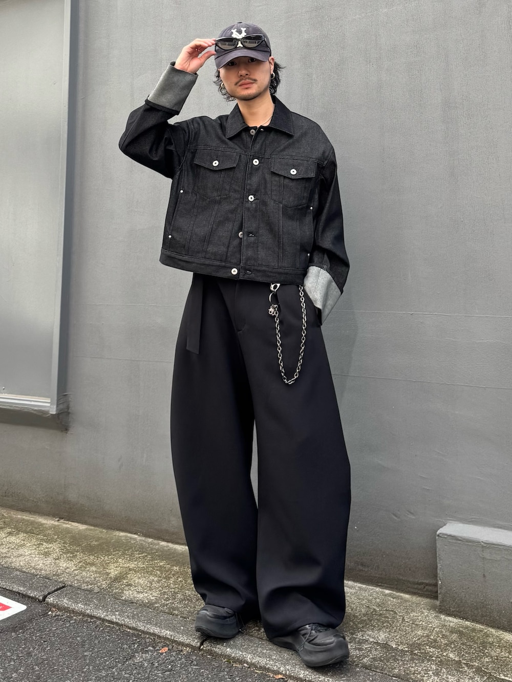 ブラック系のデニムジャケット、ブラック系のスラックス、ブラック系のウォレットチェーンを着用したメンズの春コーディネートの2枚目の写真
