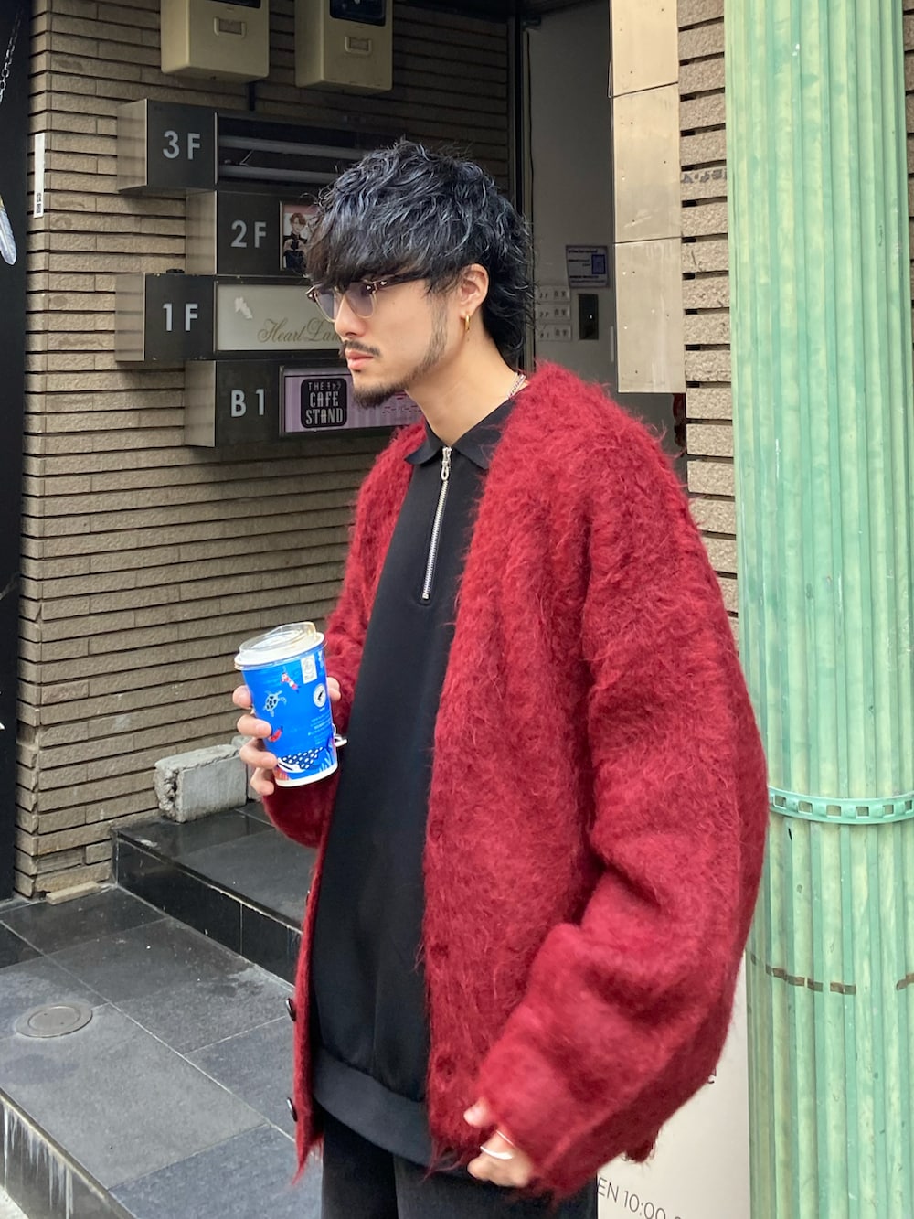 レッド系のカーディガン/ボレロ、ブラック系のデニムパンツ、ブラック系のTシャツ/カットソーを着用したメンズの秋コーディネートの2枚目の写真