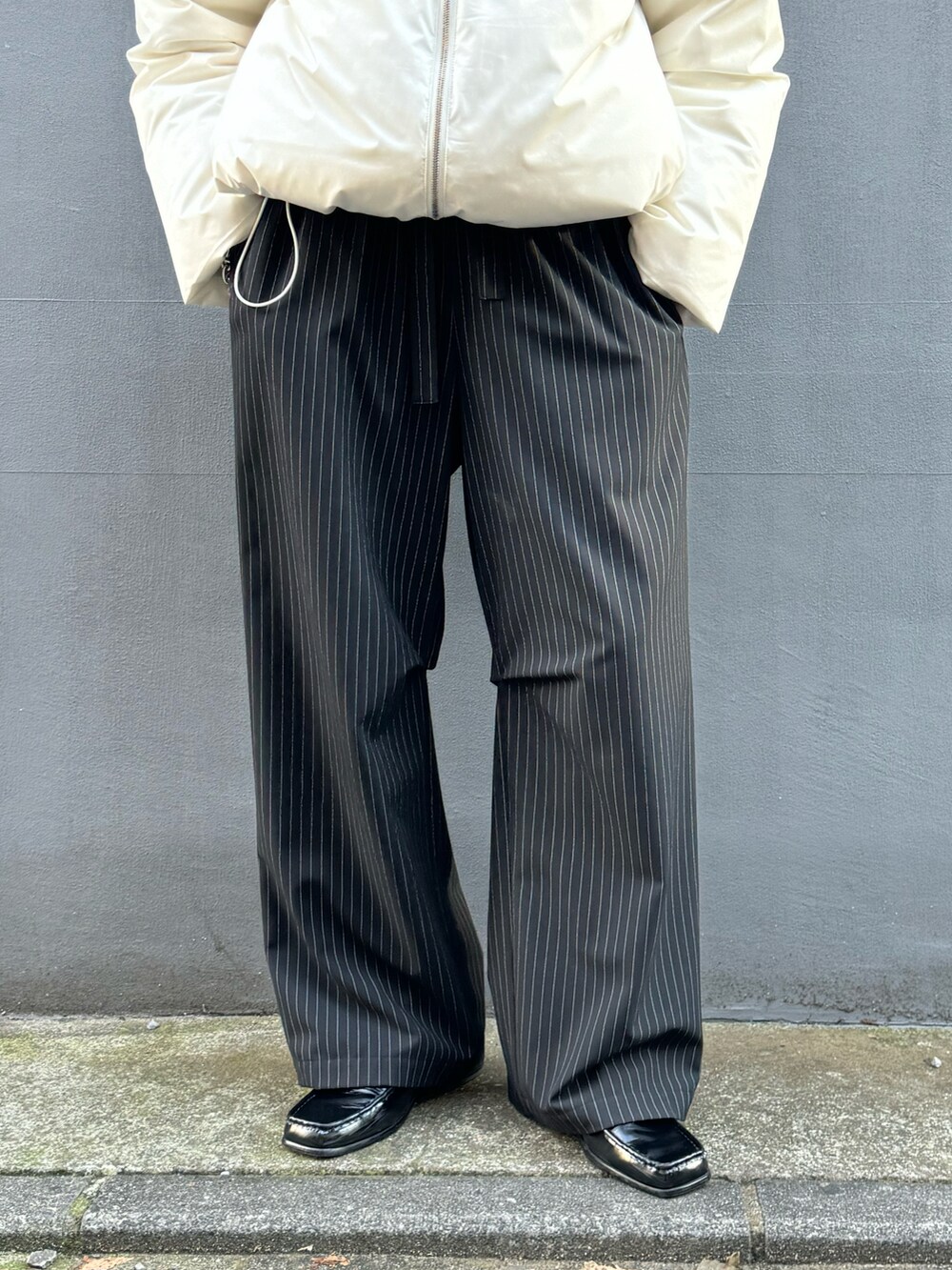 ホワイト系のブルゾン、ブラック系のその他パンツ、ブラック系のローファーを着用したメンズの冬コーディネートの5枚目の写真