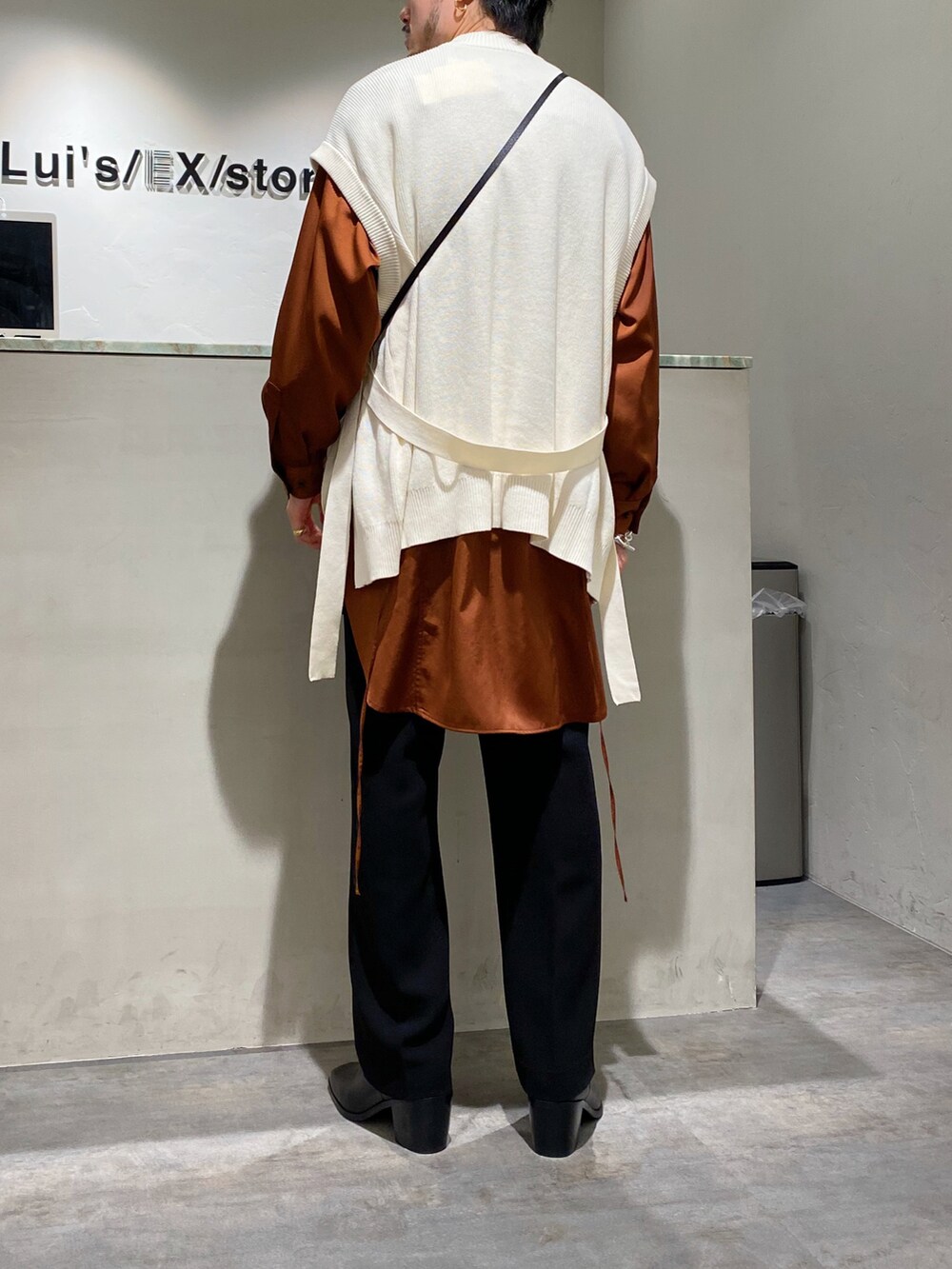 ホワイト系のベスト、ブラウン系のシャツ/ブラウス、ブラック系のスラックスを着用したメンズの春コーディネートの2枚目の写真