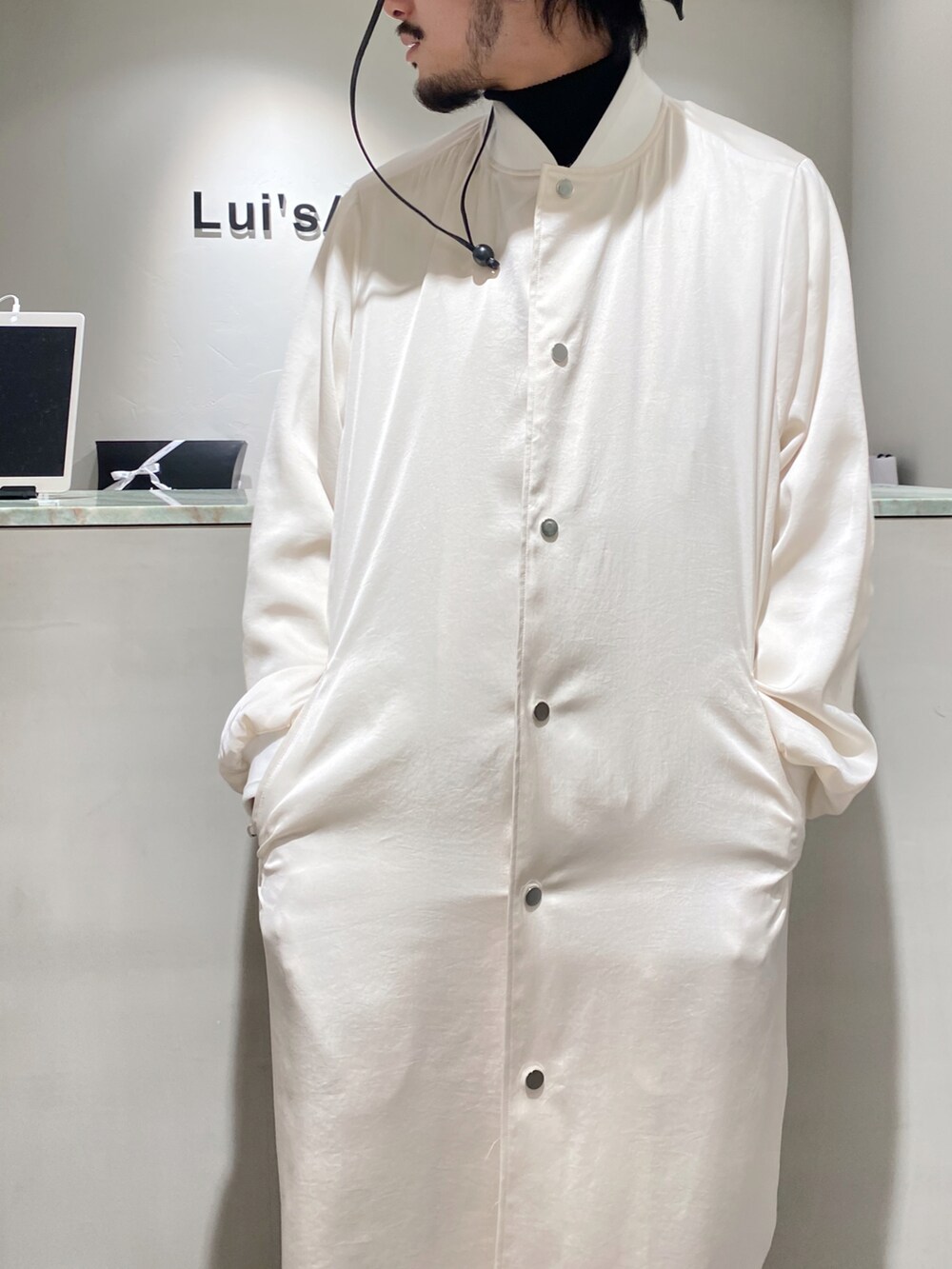 ホワイト系のブルゾン、ホワイト系のカーディガン/ボレロ、ホワイト系のスラックスを着用したメンズの冬コーディネートの3枚目の写真