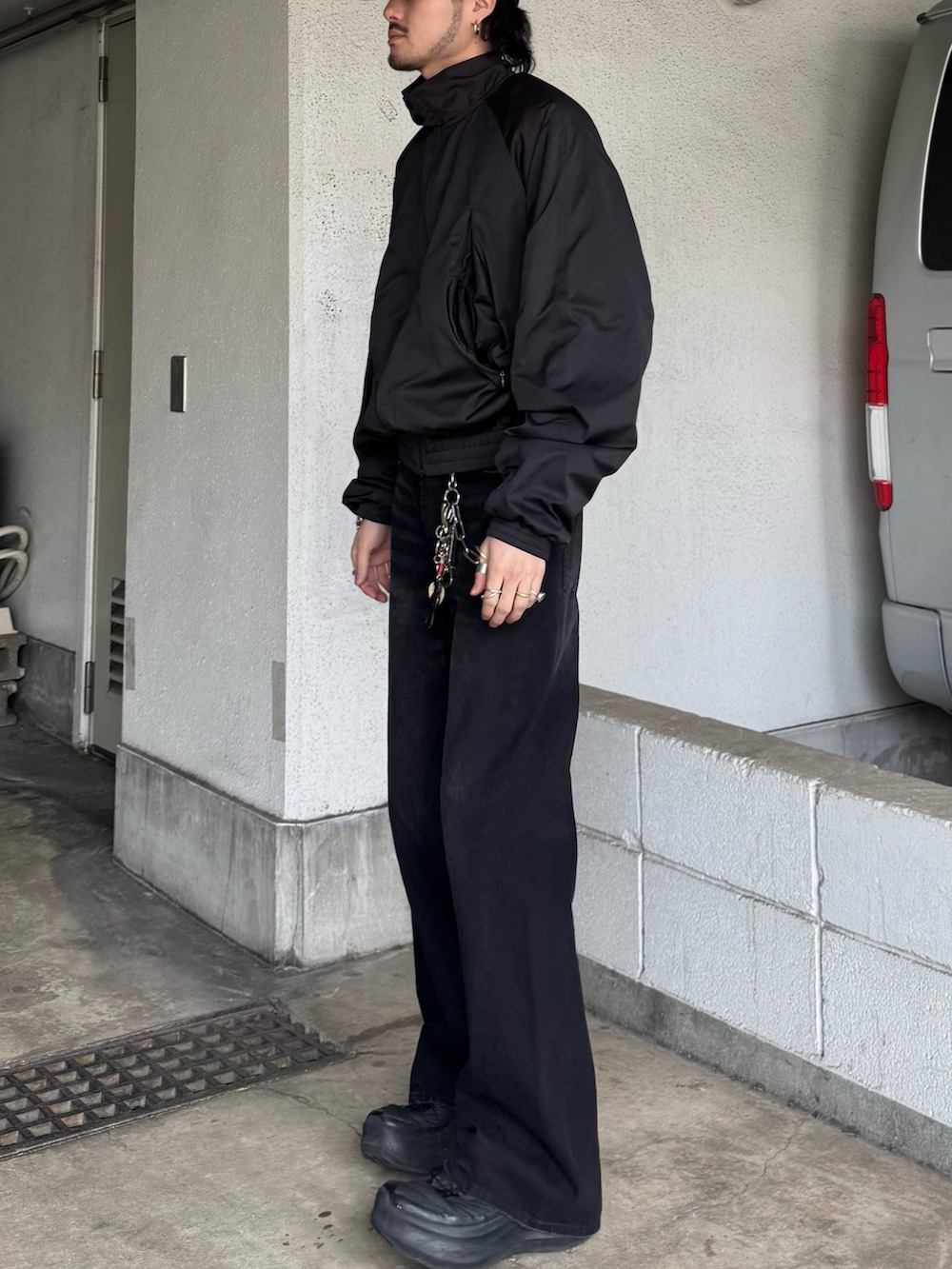 ブラック系のブルゾン、ブラック系のデニムパンツを着用したメンズの春コーディネートの4枚目の写真