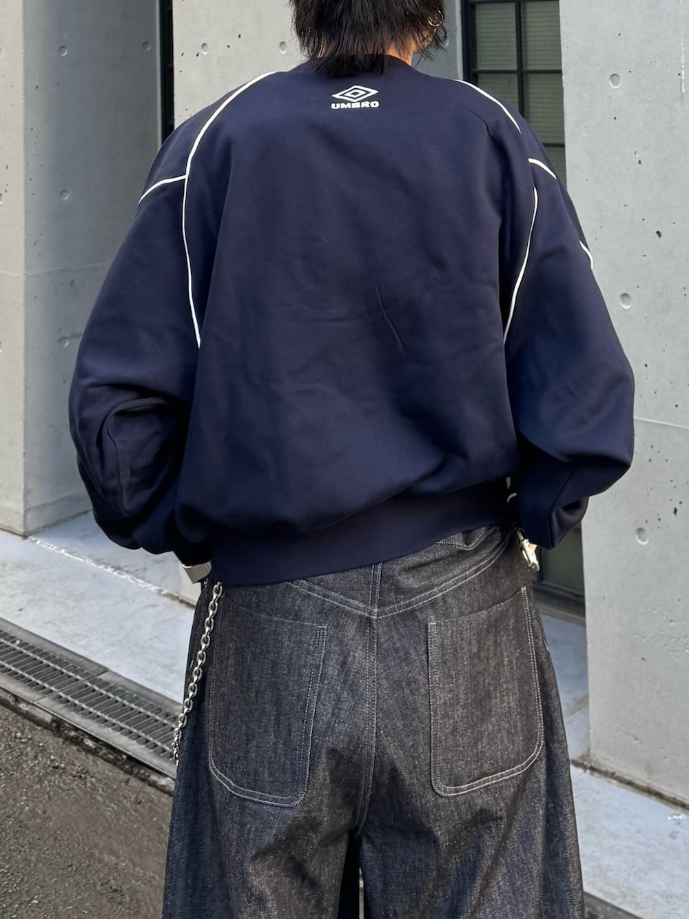 ブルー系のスウェット、ブラック系のデニムパンツを着用したメンズの冬コーディネートの8枚目の写真