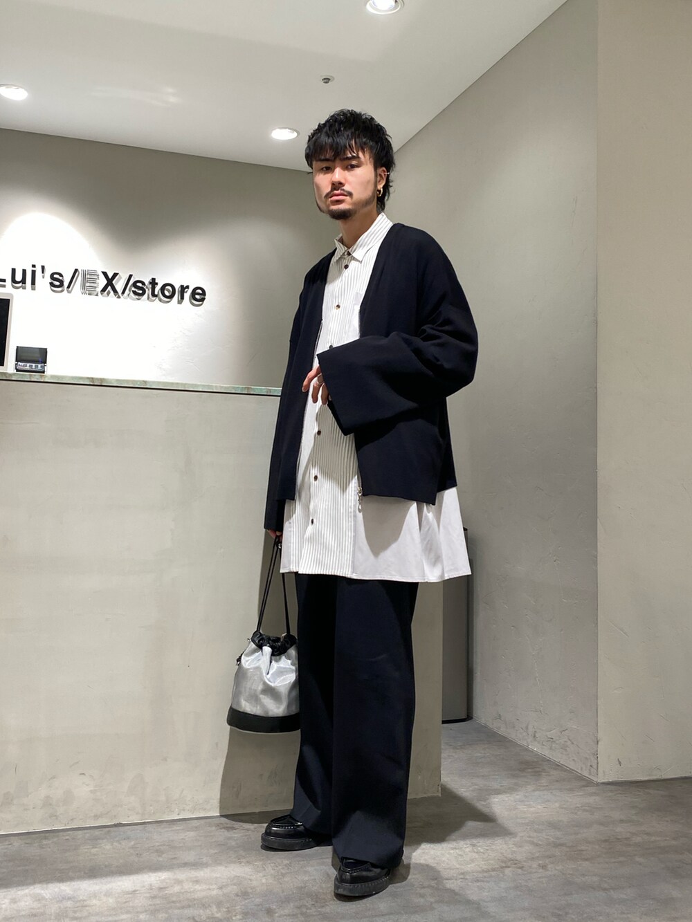 ブラック系のカーディガン/ボレロ、グレー系のシャツ/ブラウス、ブラック系のスラックスを着用したメンズの春コーディネートの2枚目の写真