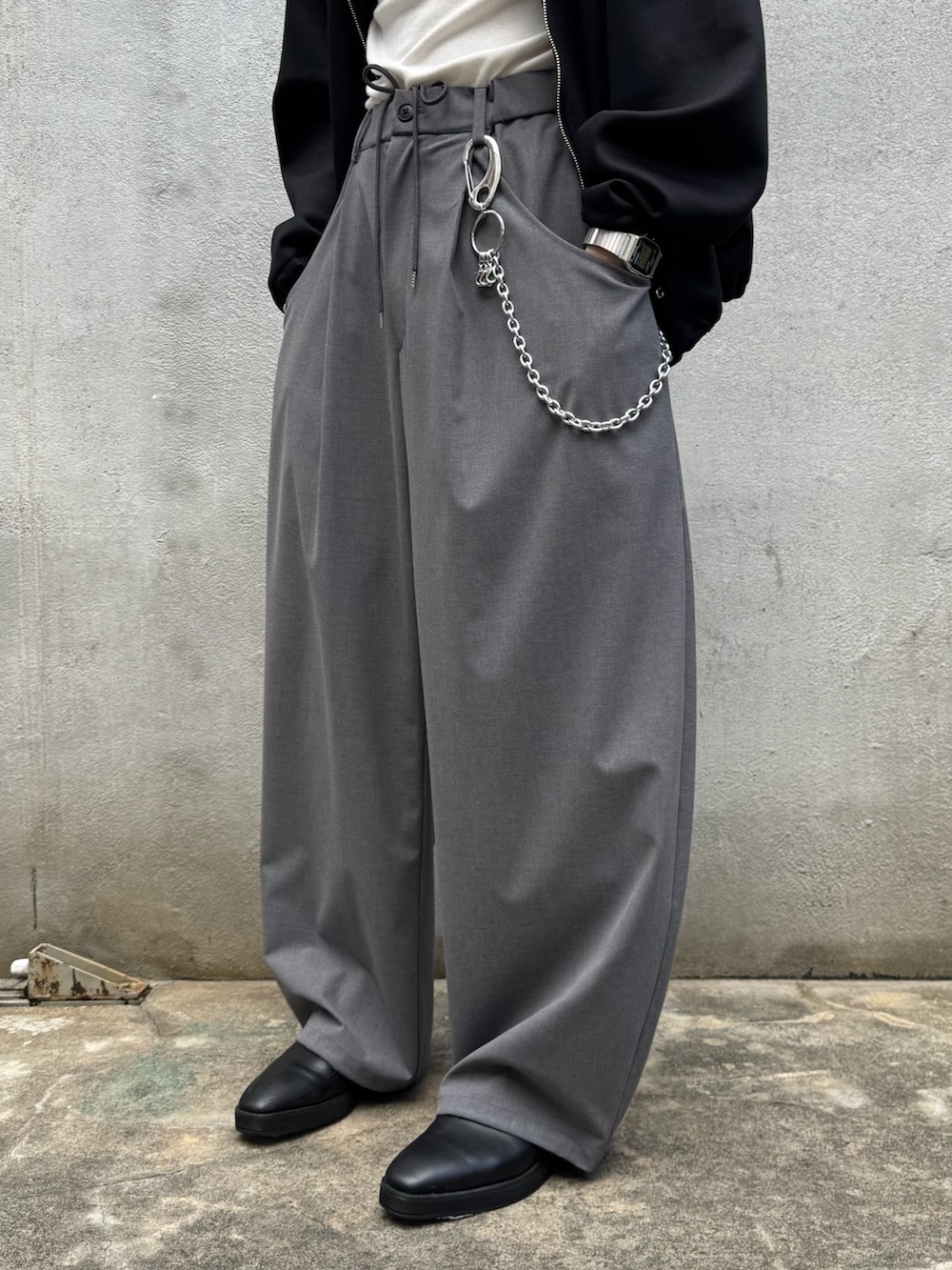 ブラック系のパーカー、グレー系のスラックス、シルバー系のウォレットチェーンを着用したメンズの秋コーディネートの10枚目の写真