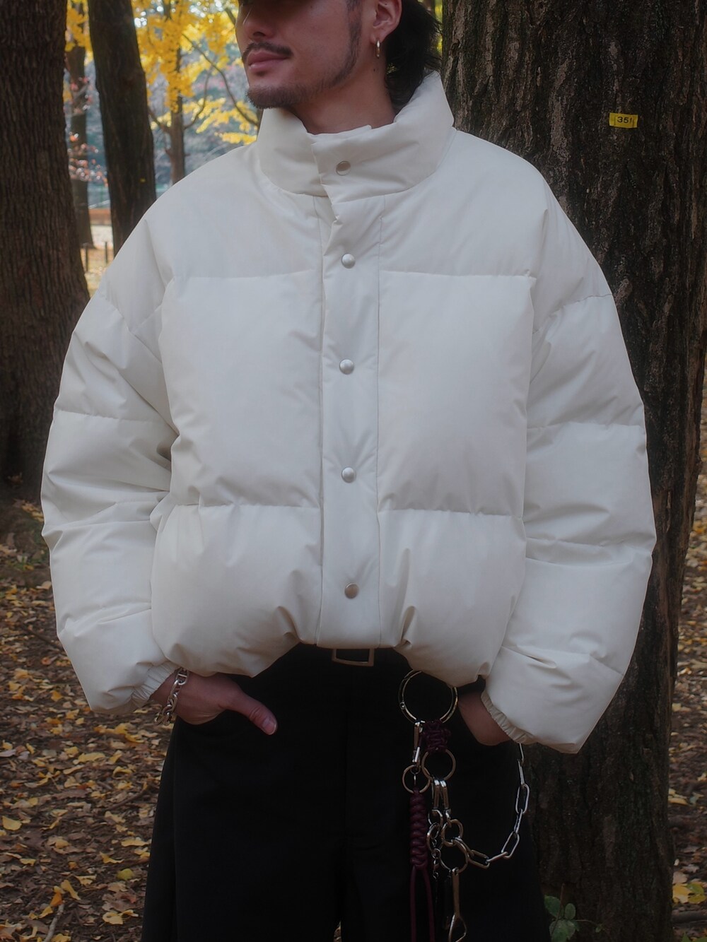 ホワイト系のダウンジャケット/コート、ブラック系のスラックスを着用したメンズの冬コーディネートの4枚目の写真